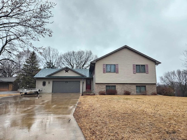 split level home with a garage, driveway, and a front yard