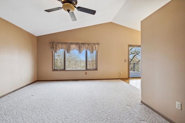 spare room featuring vaulted ceiling, light colored carpet, baseboards, and ceiling fan