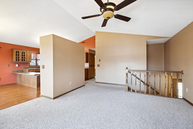 unfurnished room featuring carpet flooring, ceiling fan, baseboards, and lofted ceiling