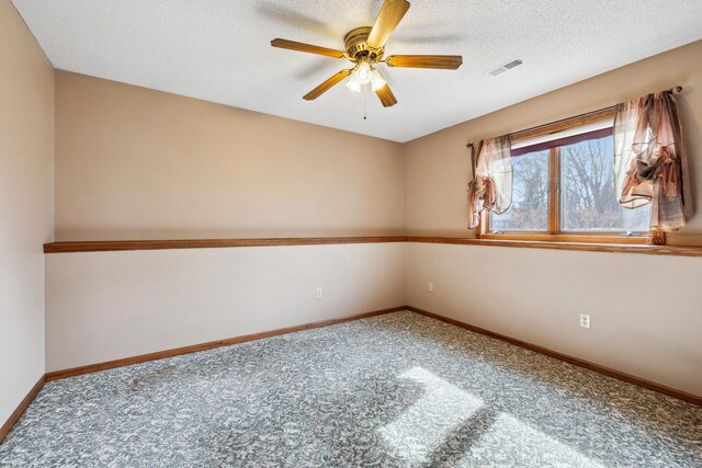 empty room with a ceiling fan, baseboards, visible vents, a textured ceiling, and carpet flooring