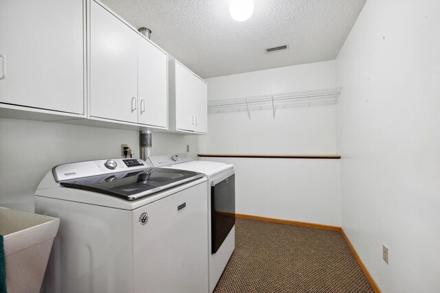 washroom featuring visible vents, cabinet space, separate washer and dryer, a sink, and a textured ceiling