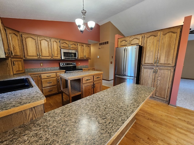 908 Park Ln, Belle Plaine, MN 56011 - kitchen featuring appliances with stainless steel finishes, lofted ceiling, brown cabinetry, light wood-style flooring, and a chandelier