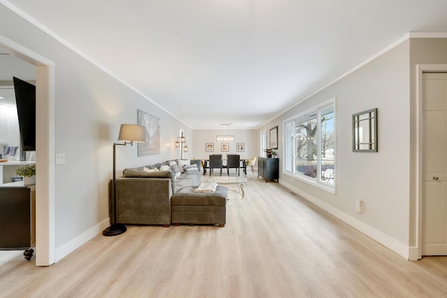 living area with light wood-style floors, baseboards, and ornamental molding