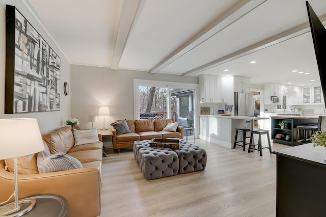 living area featuring beamed ceiling, recessed lighting, and light wood-style floors