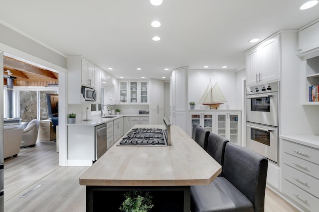 kitchen featuring a center island, white cabinetry, recessed lighting, appliances with stainless steel finishes, and light wood finished floors