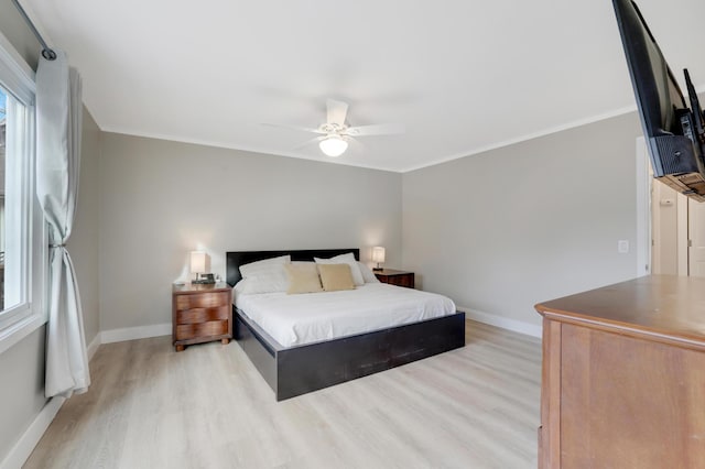 bedroom featuring baseboards, light wood-style floors, and a ceiling fan