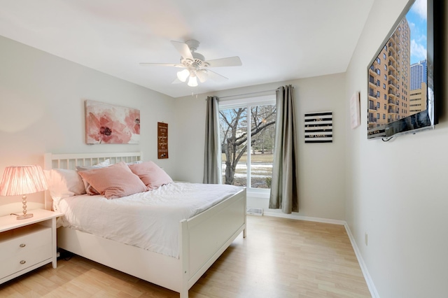 bedroom featuring light wood-style floors, baseboards, and ceiling fan