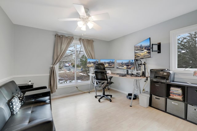 office area with baseboards, ceiling fan, and light wood finished floors