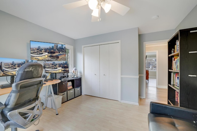 home office with light wood finished floors, baseboards, and ceiling fan