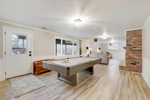 game room with visible vents, ornamental molding, wainscoting, and light wood finished floors