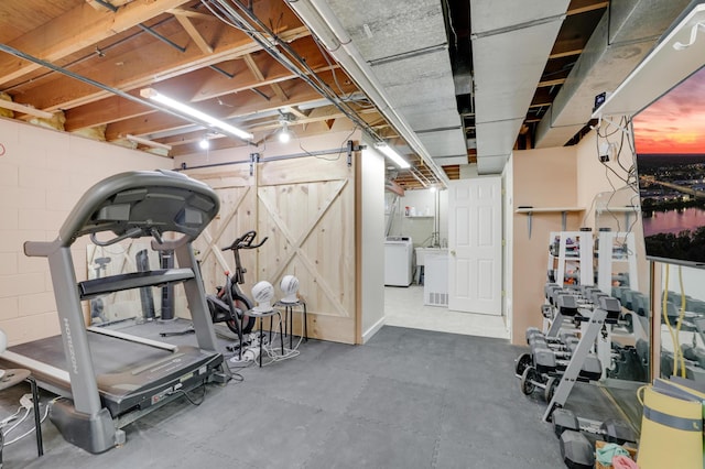 exercise room with washer / dryer and concrete block wall