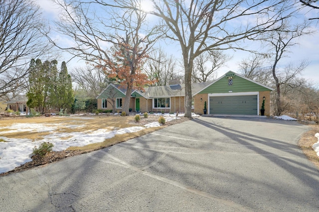 single story home with a garage, brick siding, and driveway