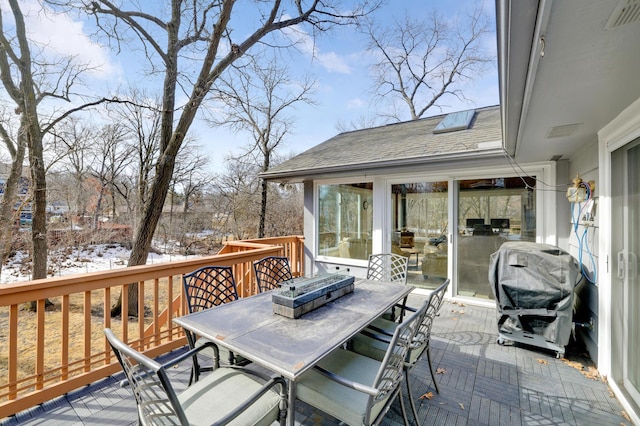 wooden terrace featuring outdoor dining space, visible vents, and grilling area