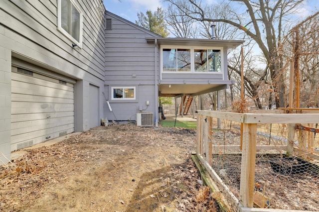 exterior space featuring stairway, cooling unit, and an attached garage