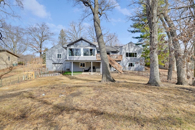 rear view of house with stairs, a deck, a yard, and fence