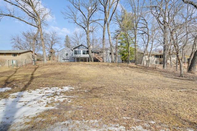 view of yard with a wooden deck, stairs, and fence