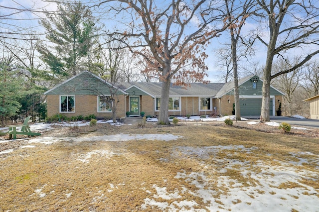 ranch-style home with brick siding, an attached garage, and driveway