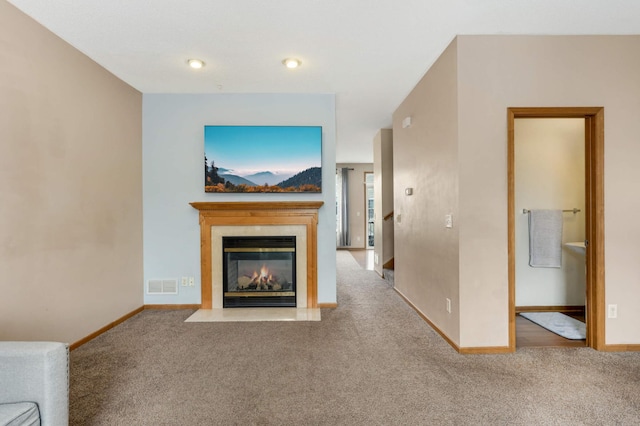 unfurnished living room featuring baseboards, carpet, visible vents, and a tiled fireplace