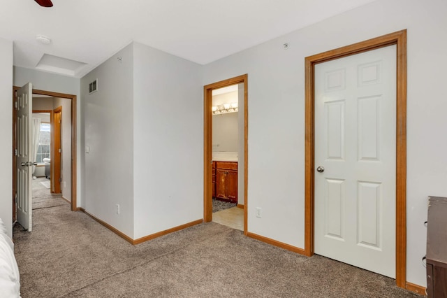 unfurnished bedroom with carpet floors, visible vents, baseboards, and ensuite bathroom