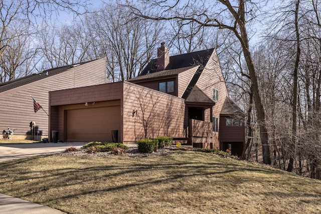 view of front facade featuring an attached garage, a chimney, a front yard, and concrete driveway