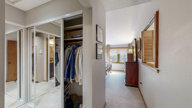corridor featuring baseboards and light colored carpet