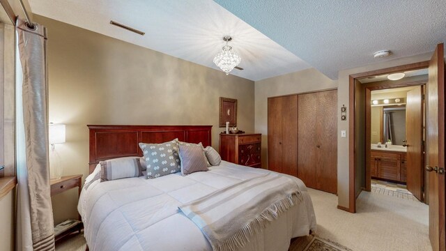 bedroom featuring light colored carpet, a notable chandelier, visible vents, and a closet