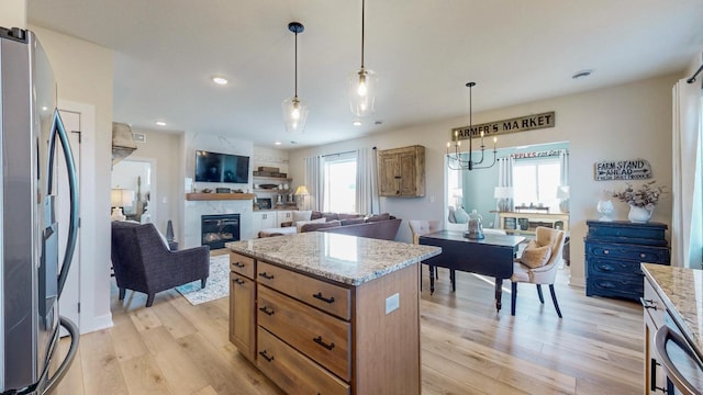 kitchen with a wealth of natural light, light wood-style flooring, open floor plan, and freestanding refrigerator