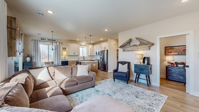 living area featuring baseboards, light wood-style flooring, and recessed lighting