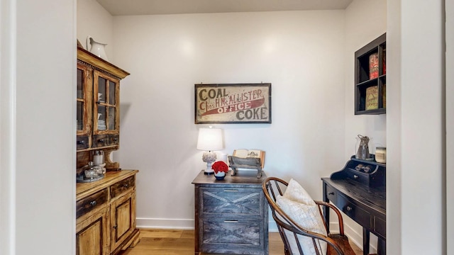 interior space featuring baseboards and light wood finished floors