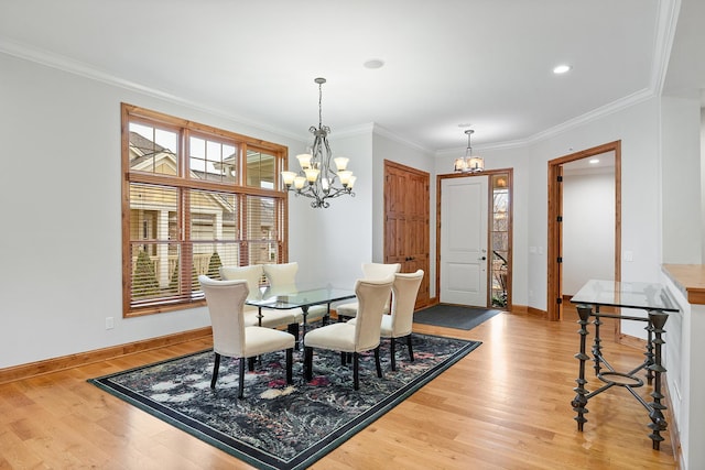 dining area featuring light wood-type flooring, crown molding, baseboards, and an inviting chandelier