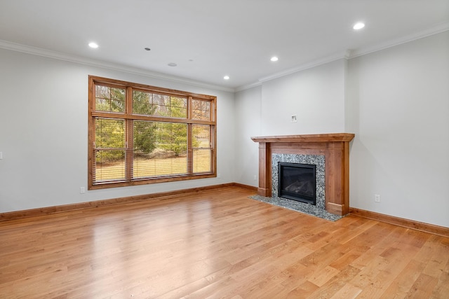 unfurnished living room with light wood finished floors, baseboards, a fireplace, and ornamental molding