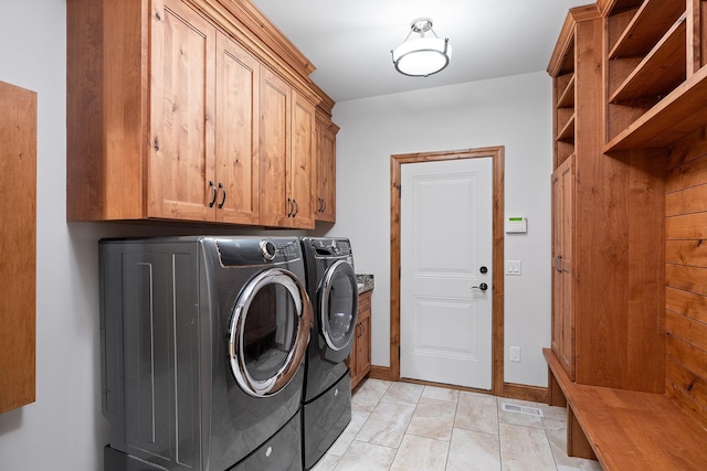 laundry room featuring baseboards, cabinet space, and washer and dryer