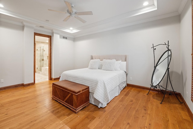 bedroom featuring light wood-type flooring, a raised ceiling, and crown molding