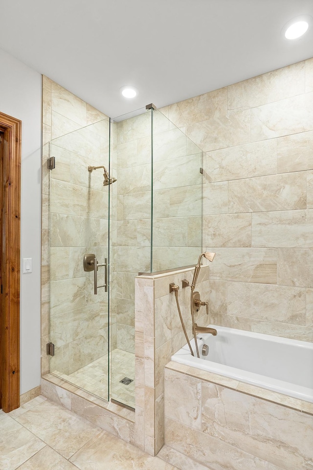 bathroom featuring tiled shower, a relaxing tiled tub, and recessed lighting