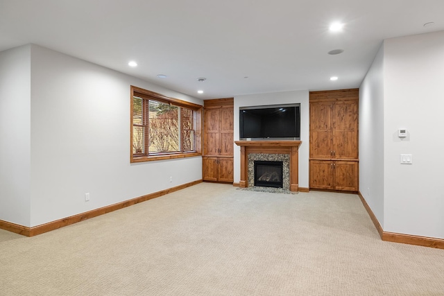 unfurnished living room featuring recessed lighting, light carpet, a tiled fireplace, and baseboards