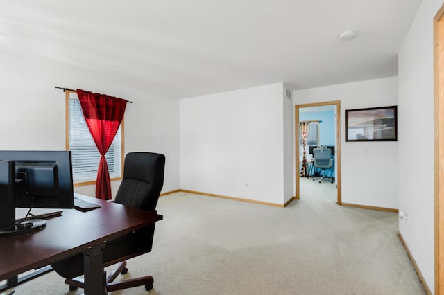 carpeted office featuring baseboards and a textured ceiling