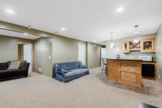 living area featuring recessed lighting, baseboards, bar, and light colored carpet