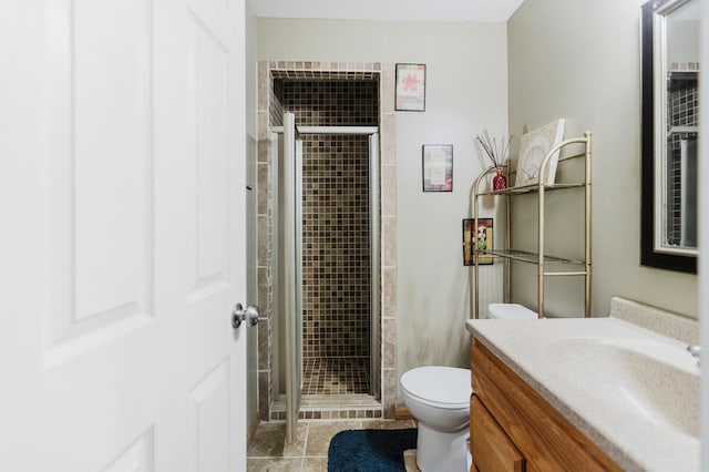 bathroom featuring toilet, a stall shower, and vanity