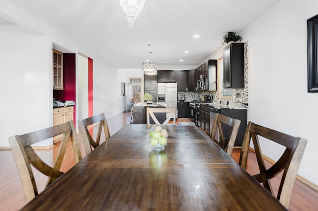 dining room featuring wood finished floors, a notable chandelier, and recessed lighting