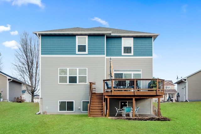 rear view of house featuring a deck, stairway, a lawn, and a shingled roof