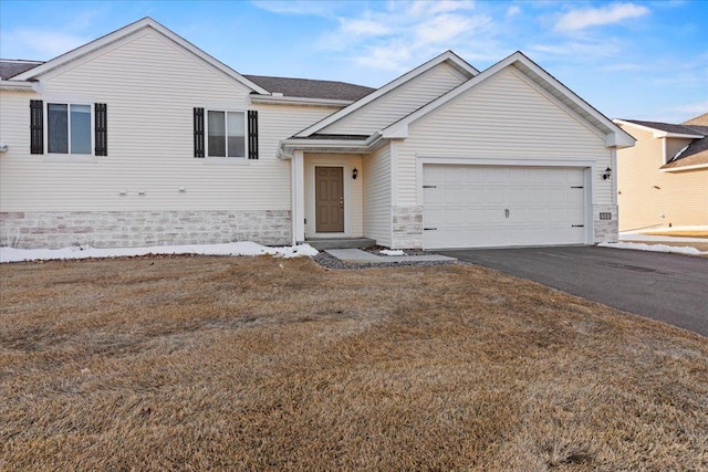 view of front of home featuring a garage, stone siding, and driveway