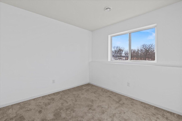 unfurnished room with carpet and baseboards