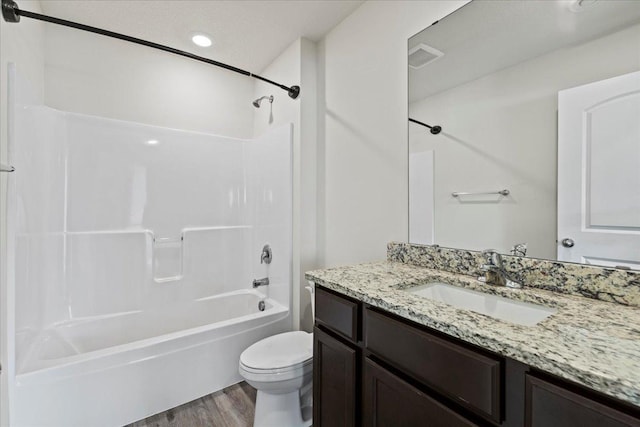 bathroom featuring shower / bath combination, visible vents, toilet, wood finished floors, and vanity