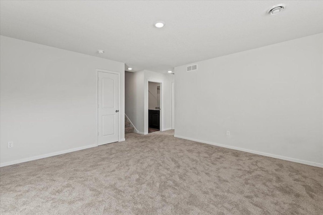 carpeted empty room featuring stairs, recessed lighting, visible vents, and baseboards