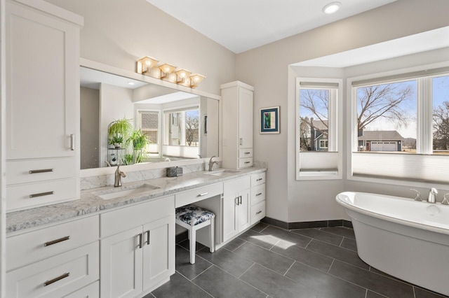 full bathroom with tile patterned floors, double vanity, baseboards, and a sink