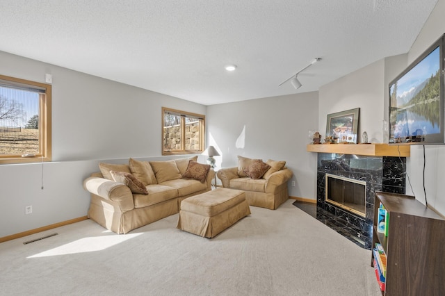 living room with baseboards, visible vents, a fireplace, a textured ceiling, and carpet flooring