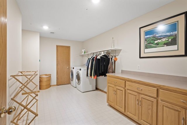 laundry area with baseboards, separate washer and dryer, light floors, and laundry area