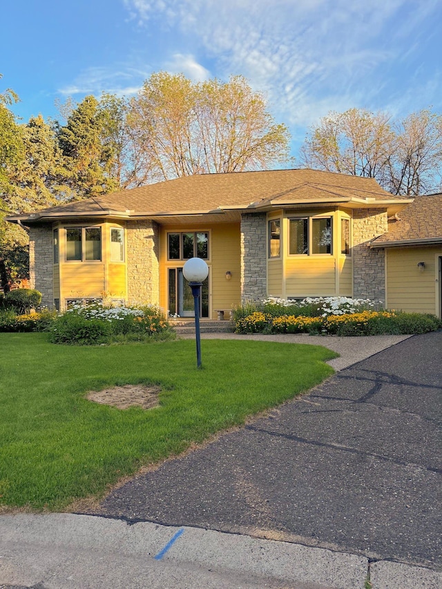 view of front of home featuring a front yard and stone siding