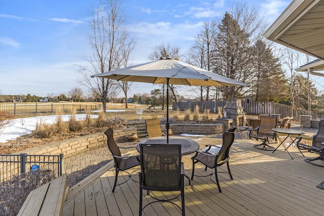 wooden terrace with outdoor dining space and fence