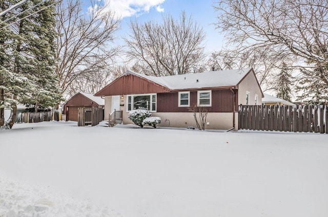 snow covered house with fence